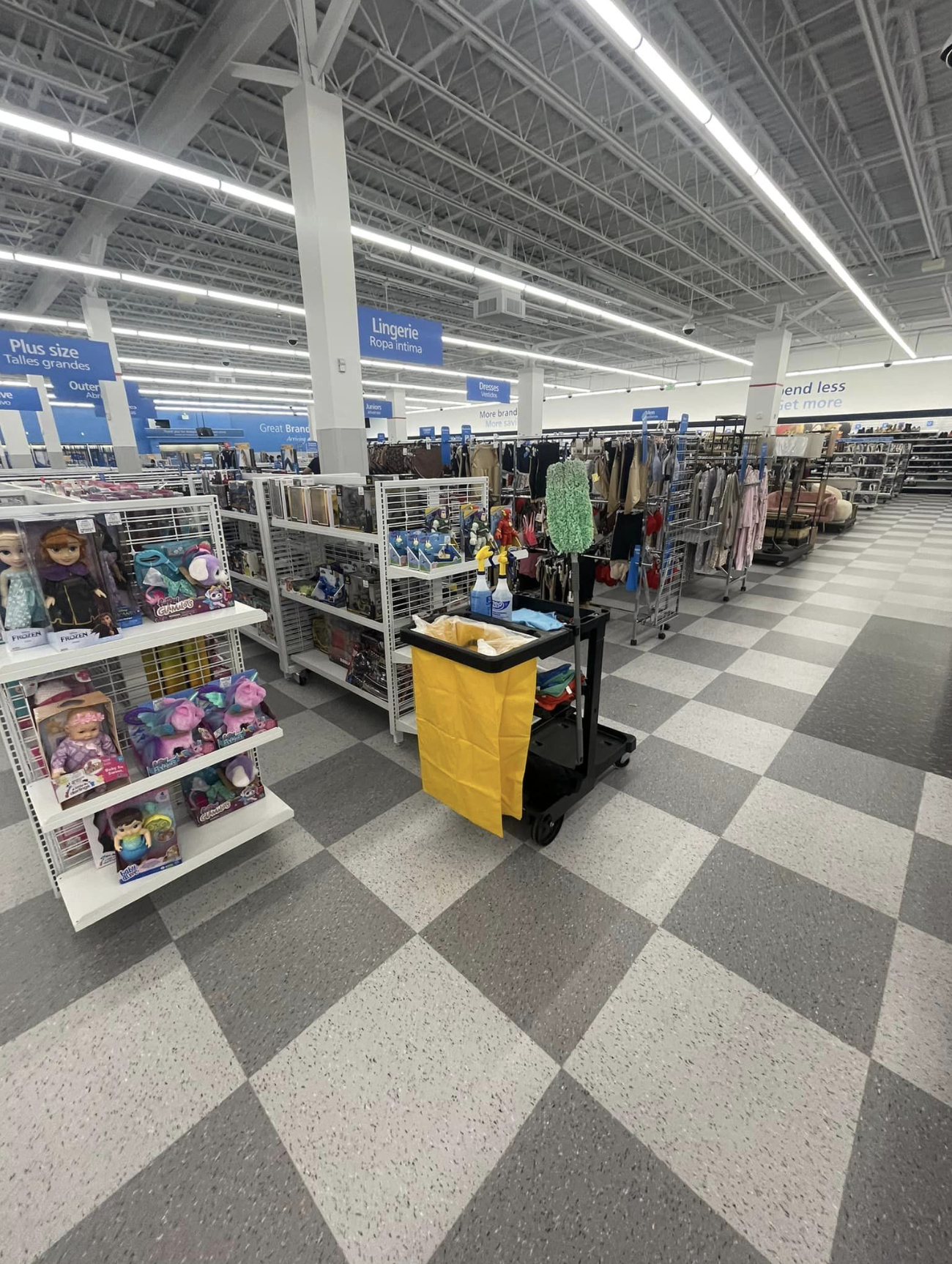 Retail store shopping aisles with cleaning cart and supplies